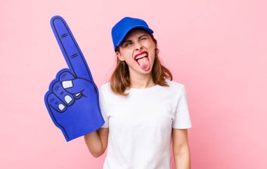 Neşeli ve asi tavırları olan genç ve güzel bir kadın, şaka yapıyor ve dilini dışarı çıkarıyor. Bir numaralı hayran konsepti