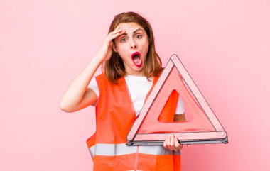 Genç ve güzel bir kadın mutlu, şaşkın ve şaşırmış görünüyor. araba üçgeni acil durum kavramı