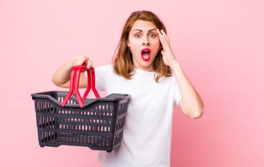 Genç, güzel bir kadın şaşırmış görünüyor, yeni bir düşünce, fikir ya da konsept fark ediyor. boş alışveriş sepeti kavramı