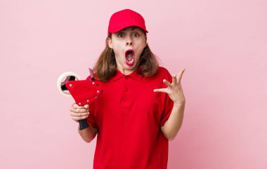 Genç ve güzel bir kadın şok olmuş ve şaşırmış hissediyor. Şirket paketleyici çalışanı