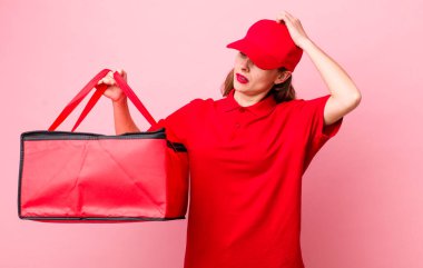 Genç ve güzel bir kadın mutlu bir şekilde gülümsüyor ve hayal kuruyor ya da şüphe ediyor. Pizza teslimatı kavramı