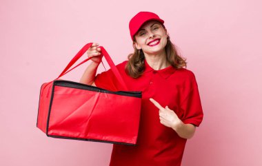 Genç, güzel bir kadın neşeyle gülümsüyor, mutlu hissediyor ve bir tarafı işaret ediyor. Pizza teslimatı kavramı