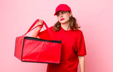 Genç, güzel bir kadın üzgün, üzgün ya da kızgın hissediyor ve yan tarafa bakıyor. Pizza teslimatı kavramı