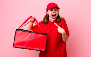 young pretty woman  looking excited and surprised pointing to the side. pizza delivery concept