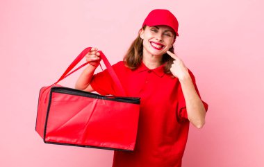 Genç ve güzel bir kadın, kendine güvenerek gülümsüyor. Pizza teslimatı kavramı