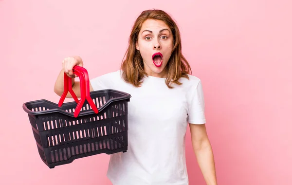 Young Pretty Woman Looking Very Shocked Surprised Empty Shopping Basket — Foto Stock