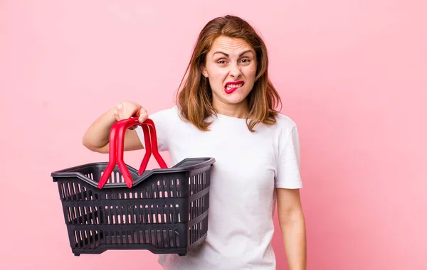 Young Pretty Woman Looking Puzzled Confused Empty Shopping Basket Concept — Stockfoto