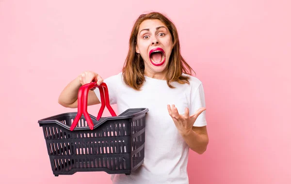 Young Pretty Woman Looking Desperate Frustrated Stressed Empty Shopping Basket — Stockfoto