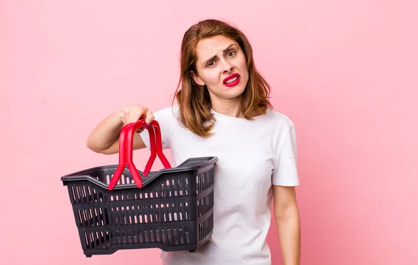 Young Pretty Woman Feeling Puzzled Confused Empty Shopping Basket Concept — Stockfoto