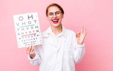 Genç ve güzel bir kadın kendini mutlu hissediyor. Onayını iyi bir hareketle gösteriyor. Optik görüş testi konsepti. Mikroskop konseptine sahip bilim adamı