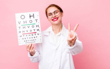 Gülümseyen ve mutlu görünen genç, güzel bir kadın zafer ya da huzur simgesi. Optik görüş testi konsepti. Mikroskop konseptine sahip bilim adamı