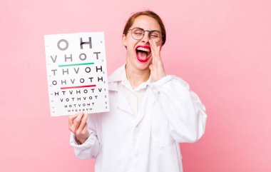 Genç, güzel bir kadın kendini mutlu hissediyor. Elleri ağzının kenarında bağırıyor. Optik görüş testi konsepti. Mikroskop konseptine sahip bilim adamı