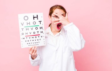 Genç, güzel bir kadın şok olmuş, korkmuş ya da korkmuş görünüyor. Optik görüş testi konsepti. Mikroskop konseptine sahip bilim adamı