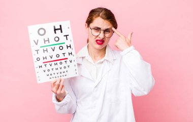 Genç ve güzel bir kadın kafası karışık ve şaşkın hissediyor, deli olduğunu gösteriyor. Optik görüş testi konsepti. Mikroskop konseptine sahip bilim adamı