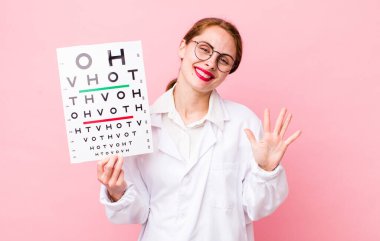 Genç, güzel bir bayan gülümsüyor ve arkadaş canlısı görünüyor, beş numarayı gösteriyor. Optik görüş testi konsepti. Mikroskop konseptine sahip bilim adamı