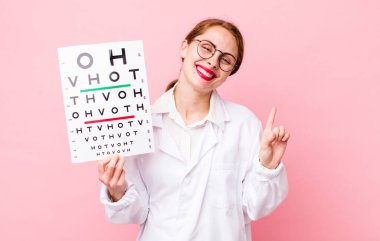 Genç, güzel bir bayan gülümsüyor ve arkadaş canlısı görünüyor. Bir numarayı gösteriyor. Optik görüş testi konsepti. Mikroskop konseptine sahip bilim adamı