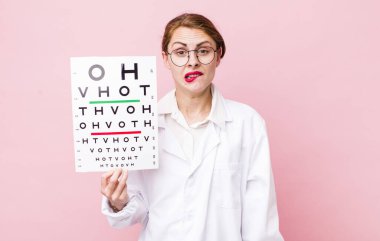 Genç, güzel bir kadın kafası karışmış ve şaşkın görünüyor. Optik görüş testi konsepti. Mikroskop konseptine sahip bilim adamı