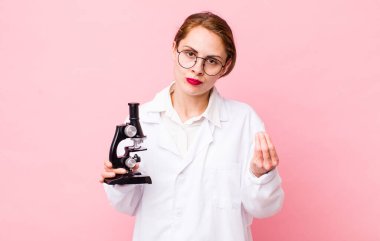 Genç ve güzel bir kadın kapiş ya da para hareketi yapıyor, sana ödemeni söylüyor. Mikroskop konseptine sahip bilim adamı