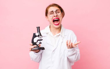 Genç ve güzel bir kadın umutsuz, hayal kırıklığına uğramış ve stresli görünüyor. Mikroskop konseptine sahip bilim adamı