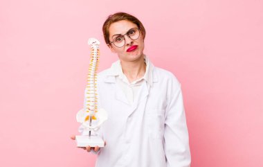 Genç ve güzel bir kadın şaşkın ve şaşkın hissediyor. Omurga uzmanı konsepti