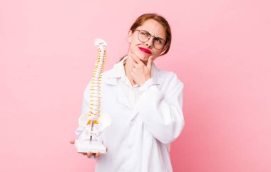 Genç, güzel bir kadın düşünüyor, kuşkulu ve şaşkın hissediyor. Omurga uzmanı konsepti