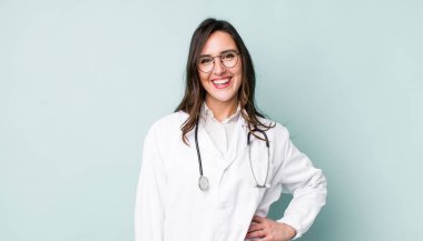 young pretty woman  smiling happily with a hand on hip and confident. physician concept