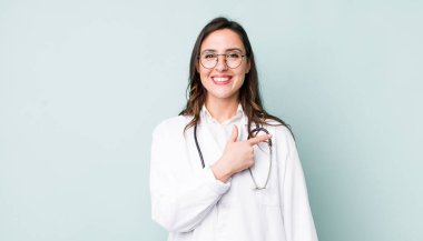 young pretty woman  smiling cheerfully, feeling happy and pointing to the side. physician concept