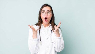 young pretty woman  amazed, shocked and astonished with an unbelievable surprise. physician concept