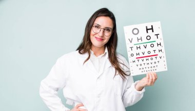 young pretty woman  smiling happily with a hand on hip and confident. optical vision test concept
