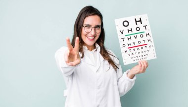 young pretty woman  smiling and looking happy, gesturing victory or peace. optical vision test concept