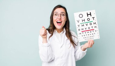 young pretty woman  feeling shocked,laughing and celebrating success. optical vision test concept