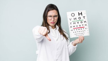 young pretty woman  feeling cross,showing thumbs down. optical vision test concept