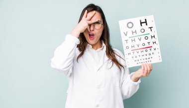 young pretty woman  looking shocked, scared or terrified, covering face with hand. optical vision test concept