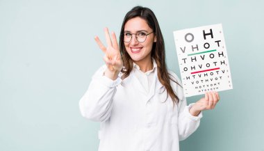 young pretty woman  smiling and looking friendly, showing number three. optical vision test concept