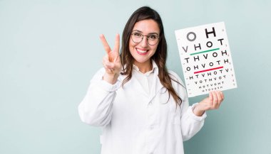 young pretty woman  smiling and looking friendly, showing number two. optical vision test concept