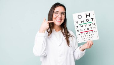 young pretty woman  smiling confidently pointing to own broad smile. optical vision test concept