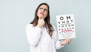 young pretty woman  thinking, feeling doubtful and confused. optical vision test concept