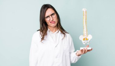 Genç ve güzel bir kadın şaşkın ve şaşkın hissediyor. Omurga uzmanı konsepti