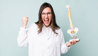 Genç ve güzel bir kadın sinirli bir ifadeyle agresif bir şekilde bağırıyor. Omurga uzmanı konsepti