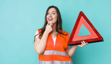 young pretty woman  smiling with a happy, confident expression with hand on chin. car emergency triangle