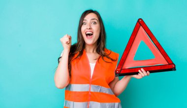 young pretty woman  feeling shocked,laughing and celebrating success. car emergency triangle