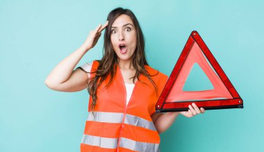 young pretty woman  looking happy, astonished and surprised. car emergency triangle