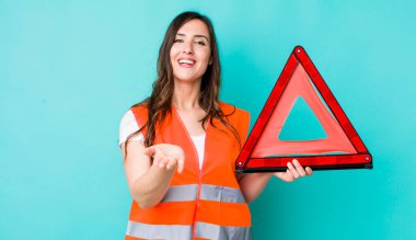 young pretty woman  smiling happily with friendly and  offering and showing a concept. car emergency triangle