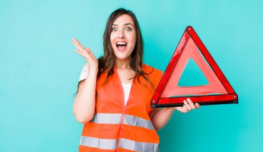 young pretty woman  feeling happy and astonished at something unbelievable. car emergency triangle