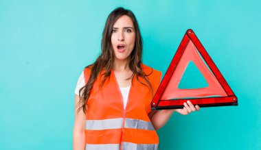young pretty woman  looking very shocked or surprised. car emergency triangle