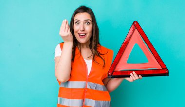young pretty woman  making capice or money gesture, telling you to pay. car emergency triangle