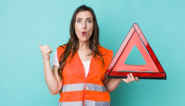 young pretty woman  looking astonished in disbelief. car emergency triangle