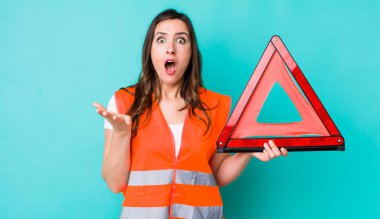 young pretty woman  amazed, shocked and astonished with an unbelievable surprise. car emergency triangle