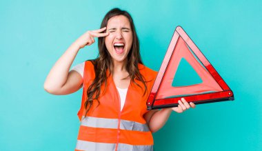young pretty woman  looking unhappy and stressed, suicide gesture making gun sign. car emergency triangle