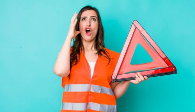 young pretty woman  screaming with hands up in the air. car emergency triangle